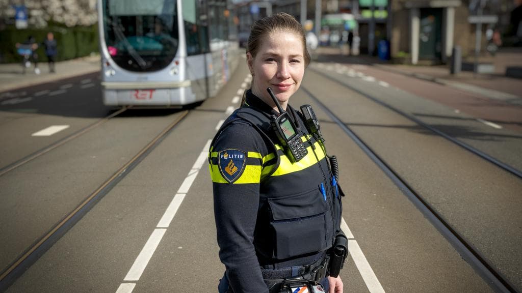 WIjkagent Anna Quist poserend op de Kleiweg met een tram op de achtergrond
