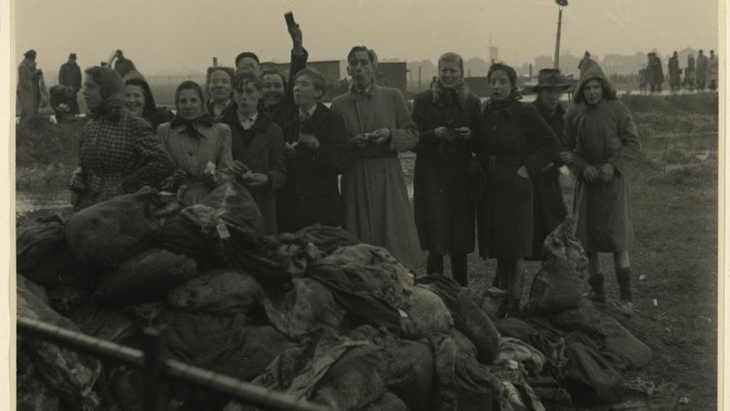 Uitgelaten mensen bij voedselpakken van de geallieerden in Terbregge, mei 1945