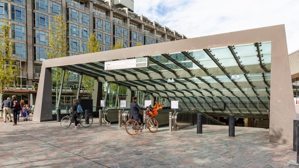 Ingang ondergrondse fietsenstalling Centraal Station met voetgangers en fietsers