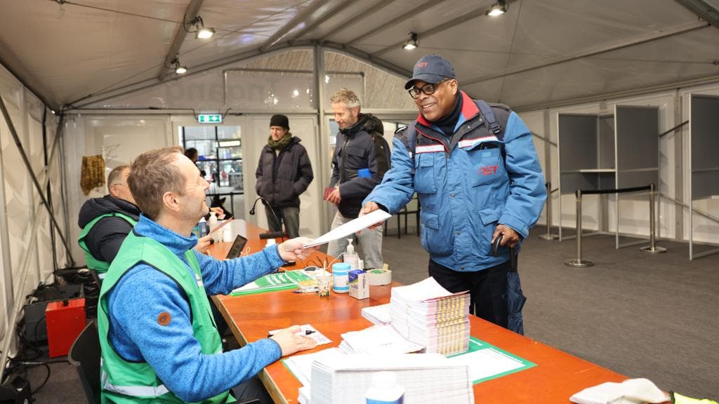 Rotterdammers brengen hun stem uit in een stembureau