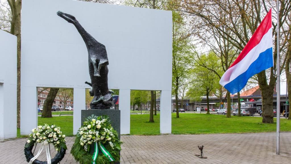 Kunstwerk Vallende Ruiter met daarnaast de gehesen Nederlandse vlag.